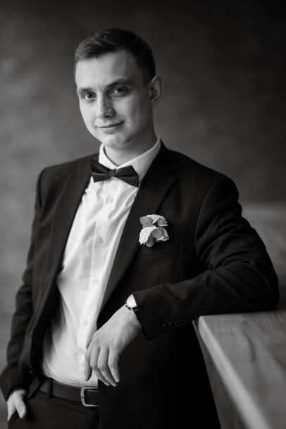 portrait of a young guy groom in a black suit on a rainy day - Foto, Imagem