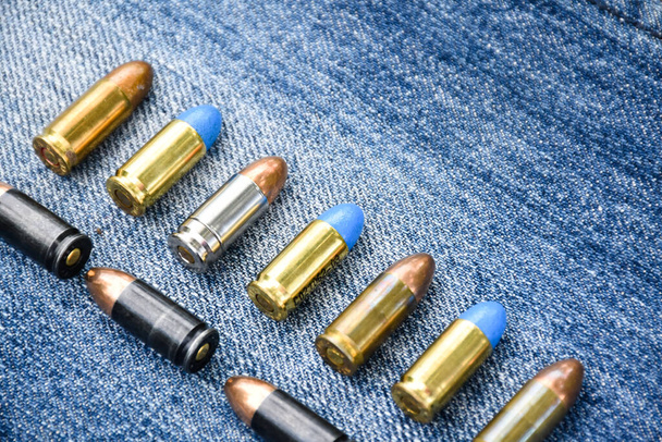 9mm pistol bullets on blue jeans, soft and selective focus, various bullets collecting concept. - Photo, image