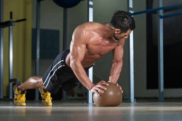 Attractive Male Athlete Performing Push-Ups On Medicine Ball - Photo, image