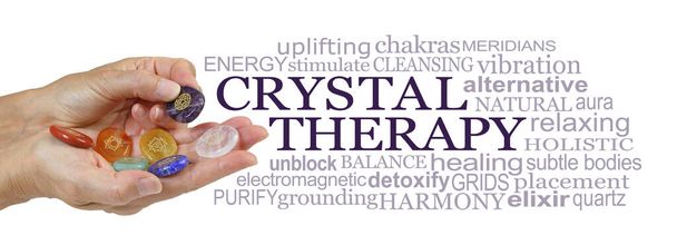 Offering you Crystal Therapy Word Cloud - female hands holding set of Crystal Chakra Symbol stones beside a CRYSTAL THERAPY word cloud against a white background - Foto, immagini