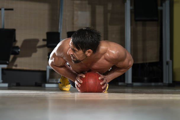 Young Man Exercising Push Ups On Medicine Ball - Фото, изображение