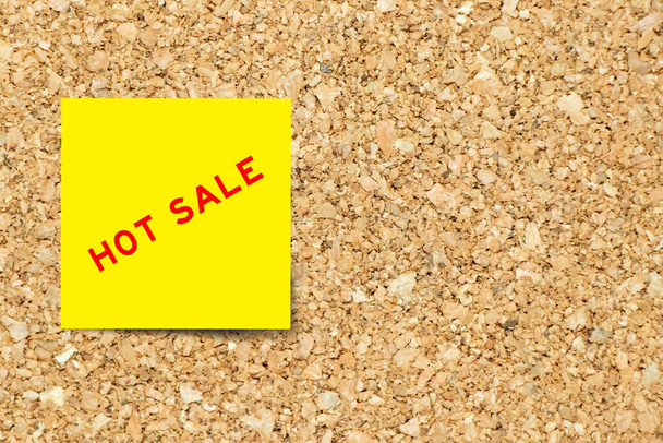Желтая бумага со словом горячая распродажа на фоне пробковой доски с копировальным пространством - Фото, изображение