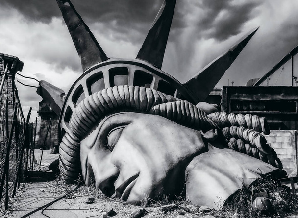 破壊された自由の像の象徴的なイメージ-世界の終わり-未来の世界の黙示録的なビジョン-気候変動、世界戦争、テロ、エイリアン攻撃のための災害コンセプト - 写真・画像