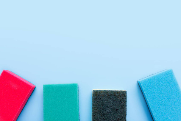 Multicolored sponges for cleaning on a blue background. Space for text - Foto, Imagem