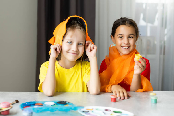 Halloween mood. two little girls are preparing for party, cutting decorations, making fall leaves. - Photo, Image