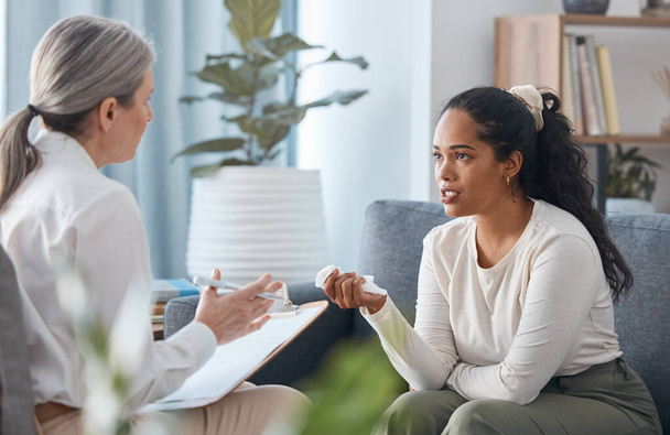 an attractive young woman sitting and talking to her psychologist during a consultation. - Foto, imagen