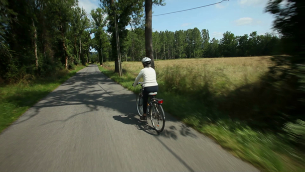 Жінка їде на велосипеді по дорозі
 - Кадри, відео