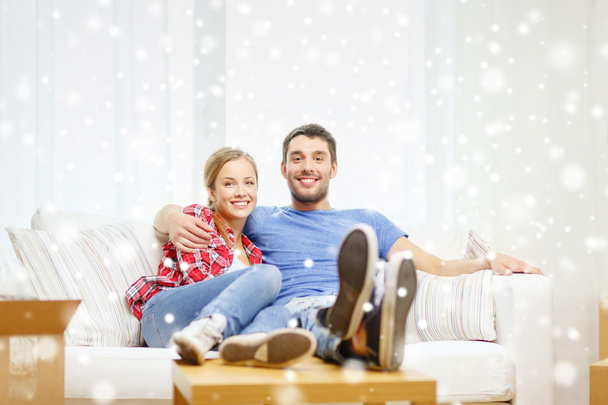 smiling couple relaxing on sofa in new home - Foto, immagini