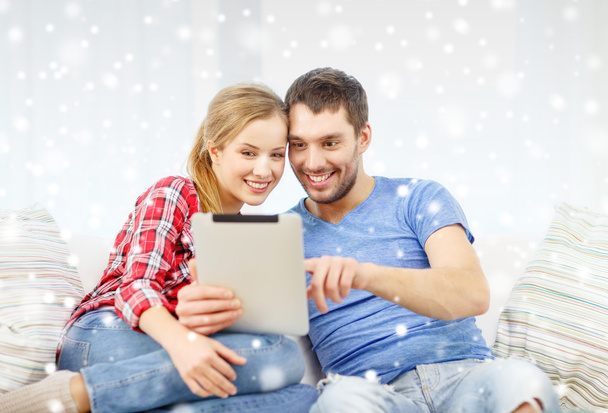 smiling couple with tablet pc computer at home - 写真・画像