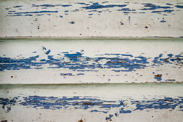 Old wood texture with horizontal boards, peeling white paint on light blue background. Old wooden planks. Abstract surface. Rustic texture of wood. Horizontal siding background with rough texture. - Φωτογραφία, εικόνα