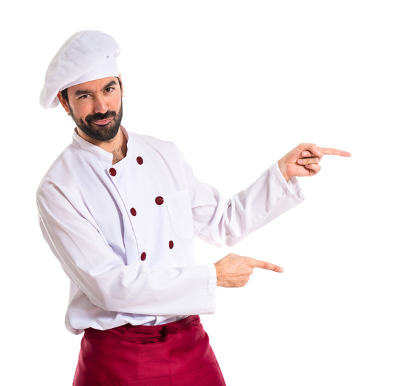 Chef pointing to the lateral over white background - Foto, Imagen