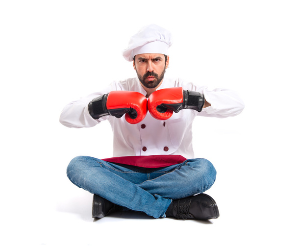 Chef with boxing gloves sitting on the floor - Фото, изображение