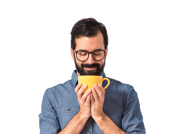 Joven hipster sosteniendo una taza de café
 - Foto, Imagen