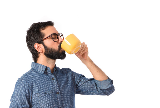 Young hipster man drinking coffee over white background - Foto, immagini