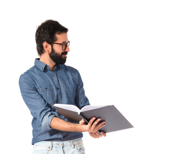 junger Hipster-Mann zeigt Buch vor weißem Hintergrund - Foto, Bild
