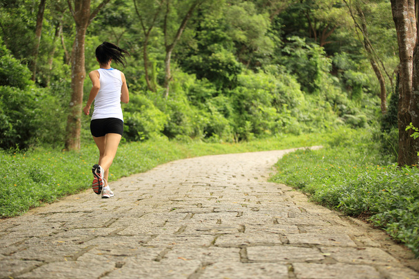 Young fitness asian woman running at forest trail - 写真・画像