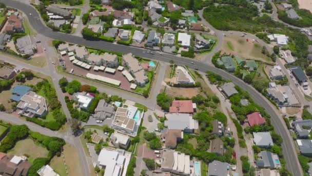 High angle view of town development along main road. Buildings, houses and residencies among green vegetation. Plettenberg Bay, South Africa. - Imágenes, Vídeo