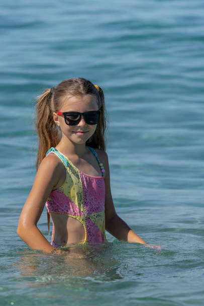 Красива дівчина-підліток в морі в сонцезахисних окулярах
. - Фото, зображення