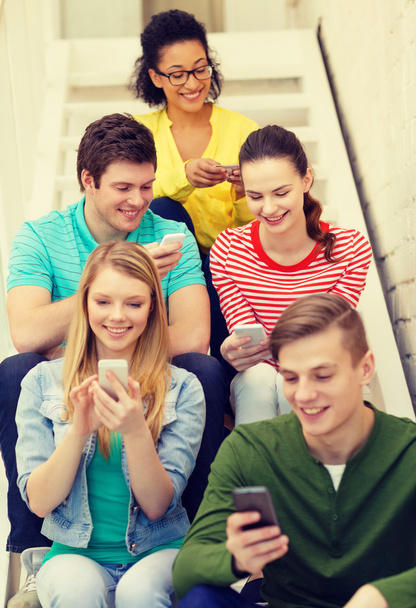 smiling students with smartphone texting at school - Φωτογραφία, εικόνα