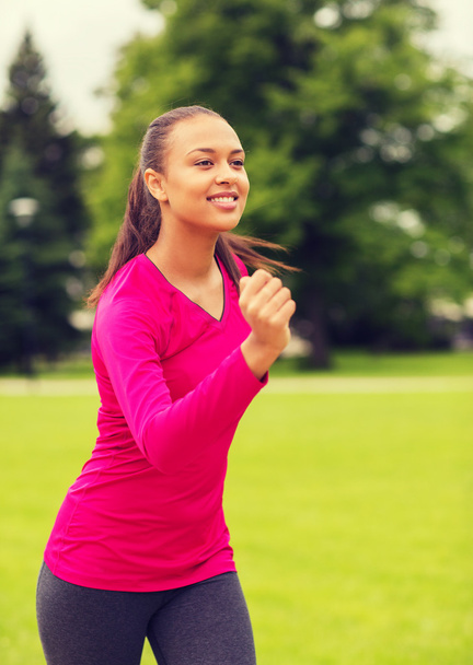 smiling young woman running outdoors - Φωτογραφία, εικόνα