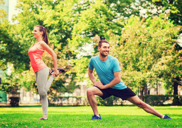 smiling couple stretching outdoors - Foto, afbeelding