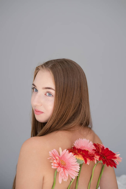 Portrait of pretty young woman with pink and red chrysanthemum flowers. - Fotografie, Obrázek