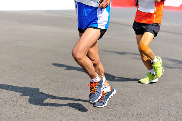 Marathon runner legs running on city road - Photo, Image
