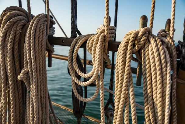 Mooring ropes coiled on fan old boat Strong braided ropes for anchoring the boat in sunset light. America - Foto, Bild