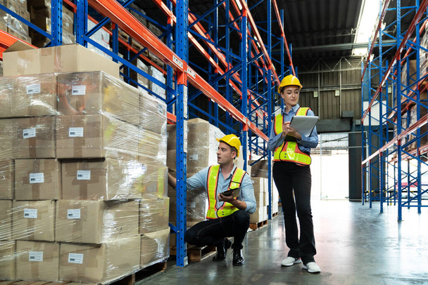 Male and Female Supervisors Hold Digital Tablet is checking the number of items in the warehouse that he is responsible for. checking goods in a warehouse by scanning a barcode. - Foto, immagini