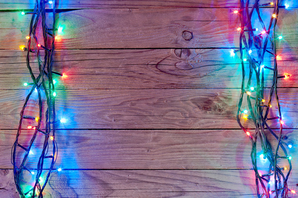 fondo de luz de Navidad sobre tablones de madera
 - Foto, imagen