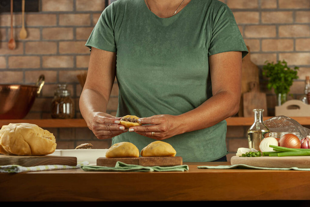Женщина готовит бразильские закуски, фаршируя крокет из говядины (risolis de carne)  - Фото, изображение