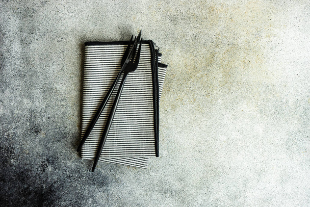 Cutlery set with textile napkin and silverware on concrete table - Valokuva, kuva