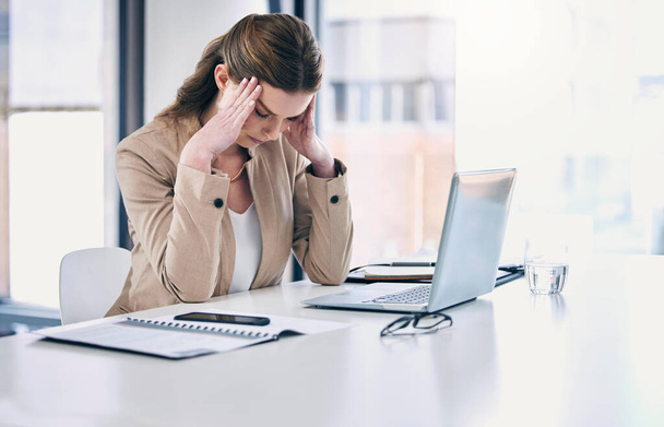I need a miracle to make it through today. a young businesswoman looking stressed out while working on a computer in an office - 写真・画像