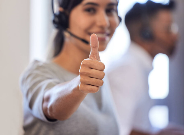 I earned a great commission on this sale. Closeup shot of a call centre agent showing thumbs up while working in an office - Φωτογραφία, εικόνα