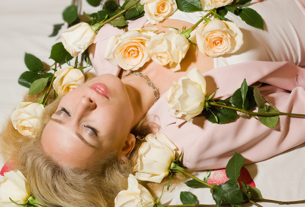Beautiful woman with roses lying on the bed - Foto, Imagem