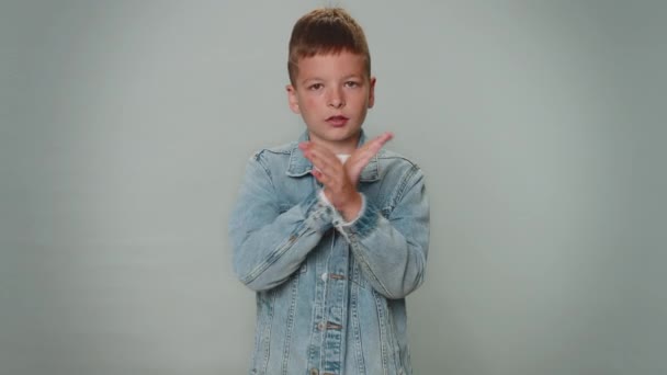 Dont want to look at this, awful. Toddler kid boy closing eyes with hand showing stop gesture, confused shy scared to watch. Young teenager child schoolboy isolated alone on gray studio background - Video, Çekim