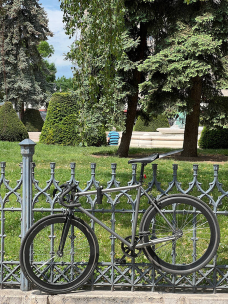 Sportfiets hangt aan een metalen hek in het park. Hoge kwaliteit foto - Foto, afbeelding