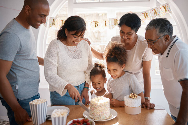 The secret of staying young is to live honestly. a family cutting a cake and celebrating a birthday party at home - Photo, Image