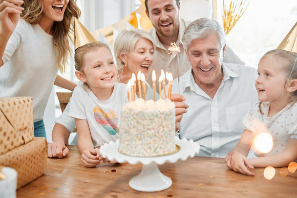 Candles are so much cooler nowadays. a happy family celebrating a birthday at home - Фото, зображення