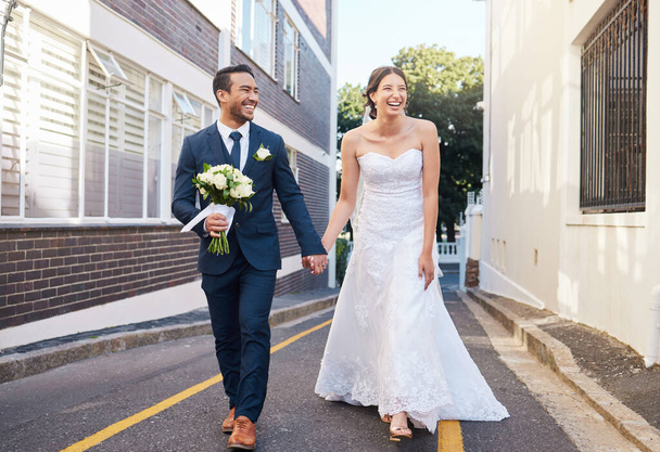 a beautiful couple walking in the city on their wedding day. - Foto, Bild
