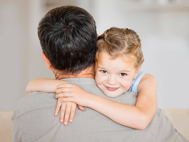 a little girl hugging her father at home. - Fotó, kép