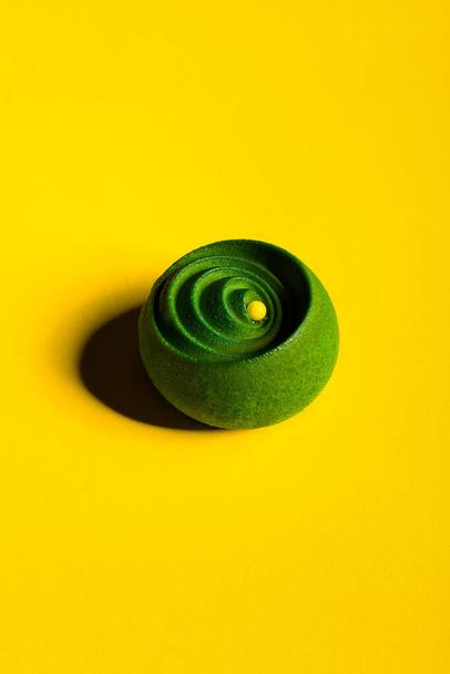 Green dessert with jam and chocolate on a yellow background - Photo, Image