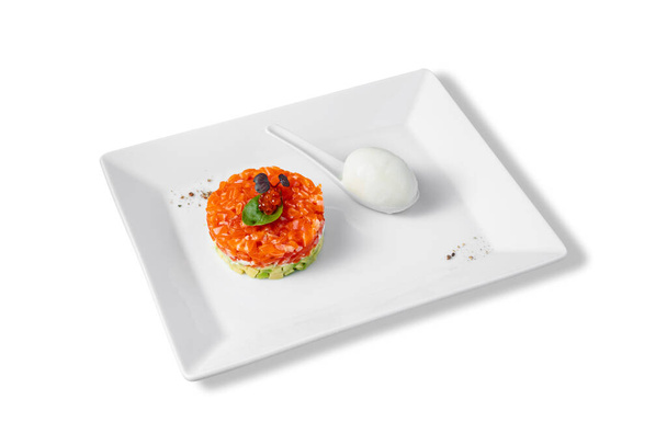 Σαλάτα με σολομό, αγγούρια, αβοκάντο, βασιλικό, κόκκινο χαβιάρι και τυρί Φιλαδέλφεια με αυγό σε πιάτο σε λευκό φόντο - Φωτογραφία, εικόνα