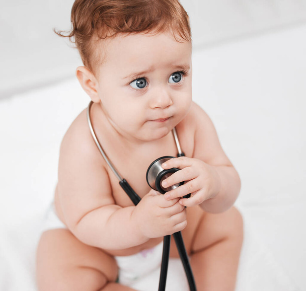 Bayan doktor, bu acıtacak mı? Muayenesi sırasında klinikte steteskop tutan sevimli bir erkek bebek. - Fotoğraf, Görsel