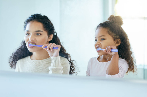 Starting our morning with fresh breath. a young mother and daughter brushing their teeth in a bathroom at home - Fotoğraf, Görsel