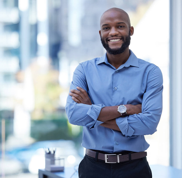 Бізнес з посмішкою. молодий бізнесмен, що стоїть зі своїми руками, схрещеними в офісі на роботі
 - Фото, зображення