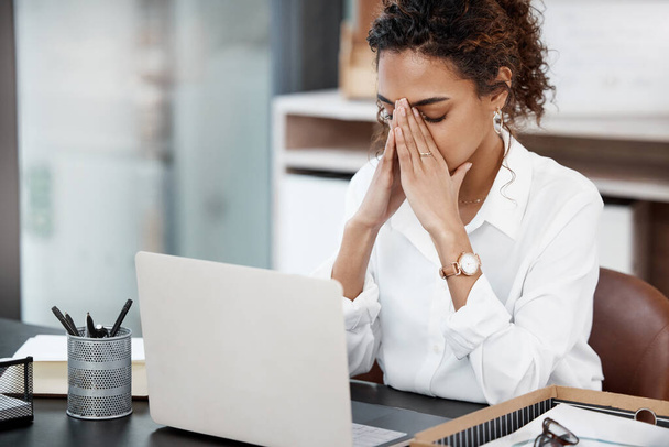 The stress can become a little too much at times. an attractive young businesswoman looking stressed while working at her desk in the office - Фото, изображение