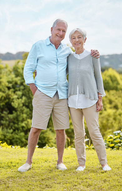 a senior couple standing together outside. - Фото, изображение