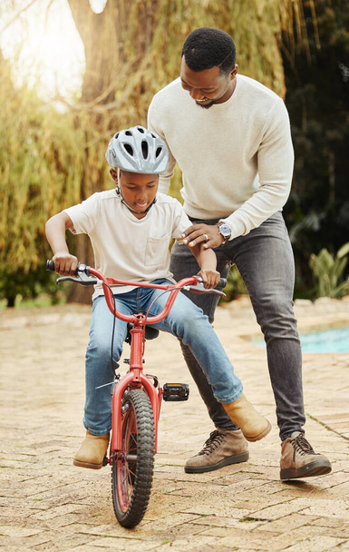 Smak wolności. uroczy chłopiec uczy się jeździć na rowerze z ojcem na świeżym powietrzu - Zdjęcie, obraz