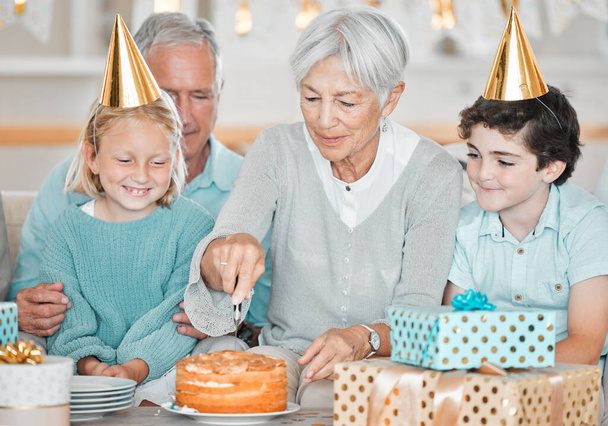 dwoje uroczych małych dzieci świętujących urodziny w domu z dziadkami. - Zdjęcie, obraz